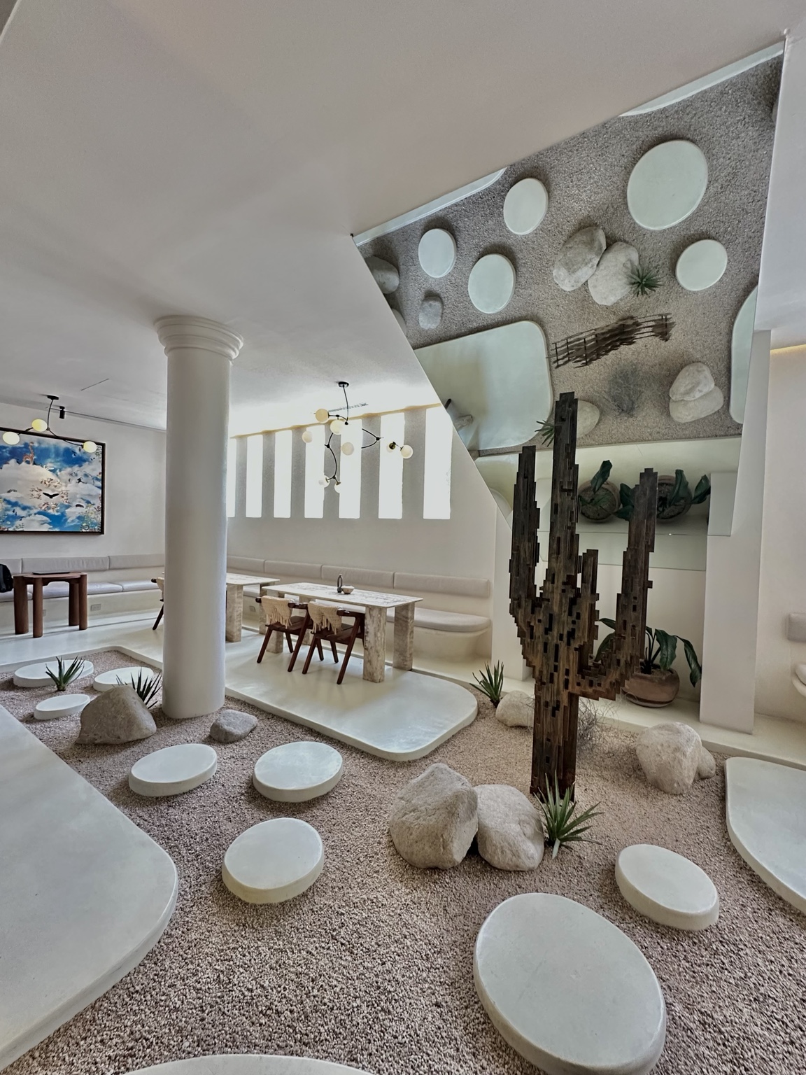 A neutral hospitality interior with a rock garden, stepping stones and sculptural architecture
